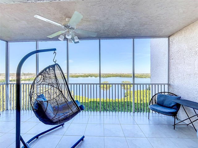 sunroom featuring plenty of natural light, a water view, and ceiling fan