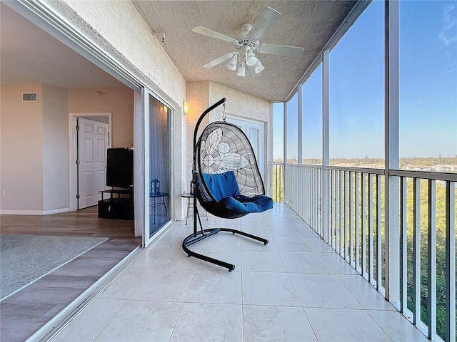 unfurnished sunroom featuring ceiling fan