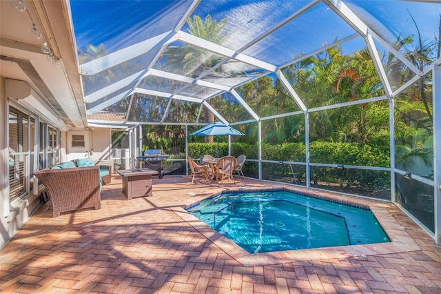 view of pool featuring glass enclosure and a patio area