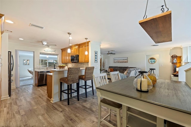 dining area featuring ceiling fan, hardwood / wood-style floors, and crown molding