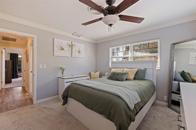 bedroom with ceiling fan, crown molding, and light carpet