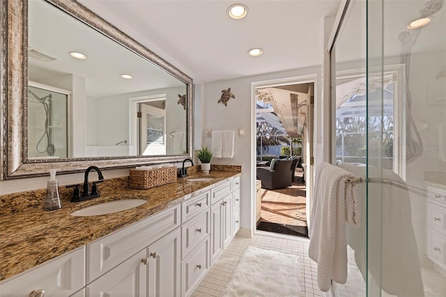 bathroom with double vanity, a stall shower, a sink, and recessed lighting