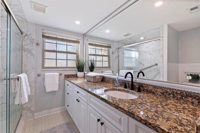 bathroom featuring tile patterned flooring, visible vents, vanity, and a marble finish shower