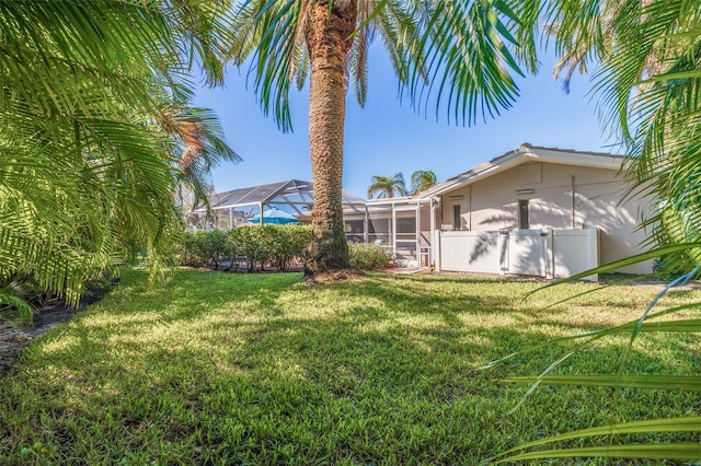 view of yard with a lanai and fence