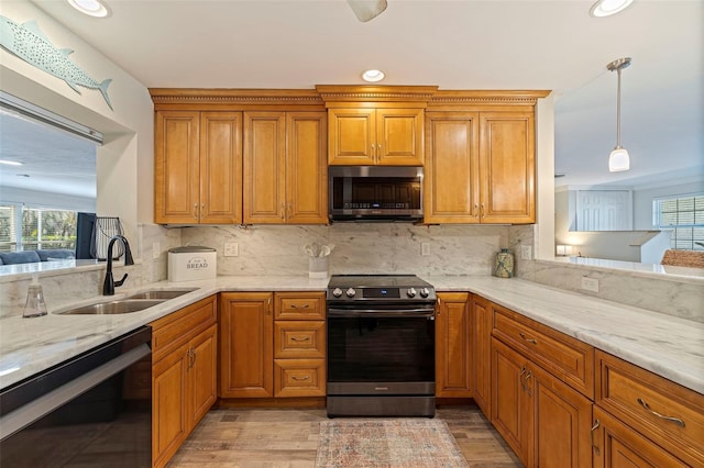 kitchen with hanging light fixtures, tasteful backsplash, stainless steel appliances, and a sink