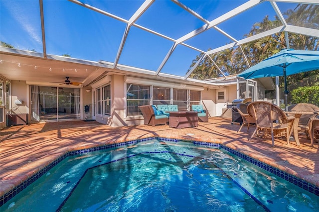 outdoor pool featuring a ceiling fan, a patio area, glass enclosure, and an outdoor hangout area