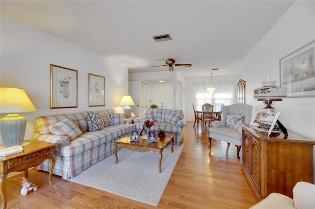 living room with ceiling fan and light hardwood / wood-style flooring