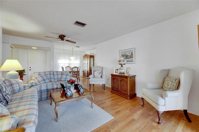 living room with light hardwood / wood-style flooring and ceiling fan