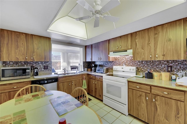 kitchen with backsplash, stainless steel appliances, sink, and ceiling fan