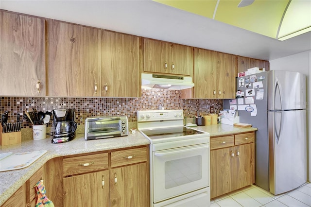 kitchen featuring stainless steel fridge, light tile patterned floors, backsplash, and electric stove