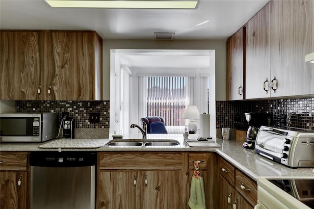 kitchen featuring appliances with stainless steel finishes, tasteful backsplash, and sink