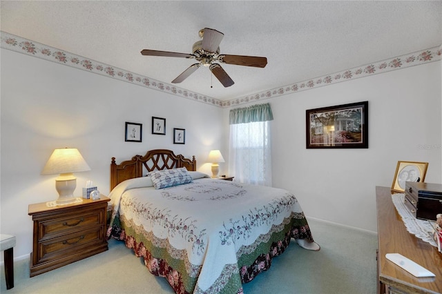 bedroom featuring light carpet, a textured ceiling, and ceiling fan