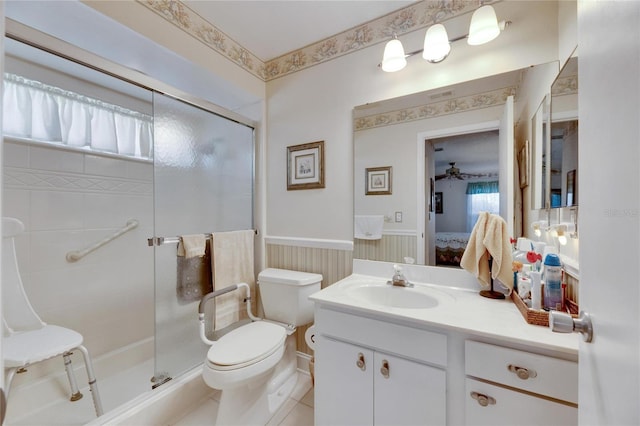 bathroom featuring vanity, an enclosed shower, toilet, and ceiling fan