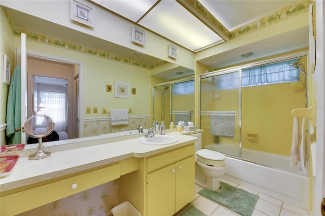 full bathroom featuring vanity, bath / shower combo with glass door, toilet, and tile patterned floors