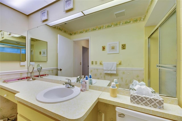 bathroom with vanity, toilet, and a shower with shower door