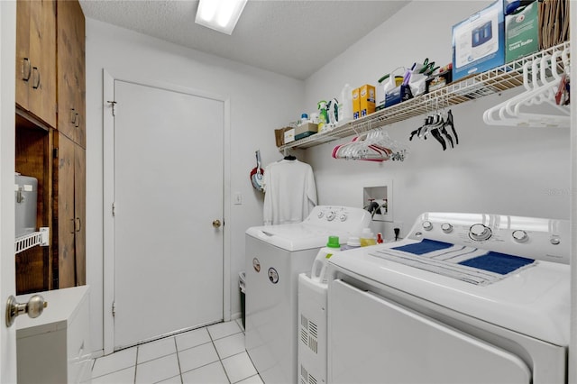 laundry area with light tile patterned flooring, a textured ceiling, and separate washer and dryer