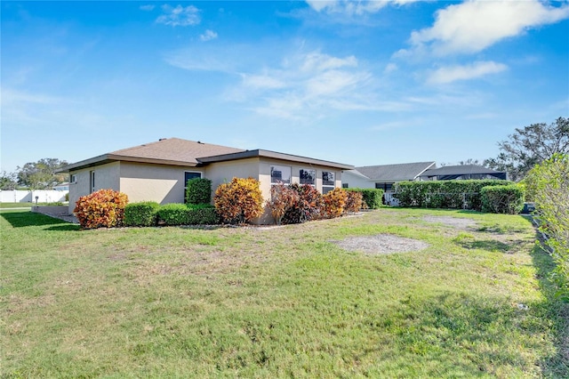 view of side of home with a yard