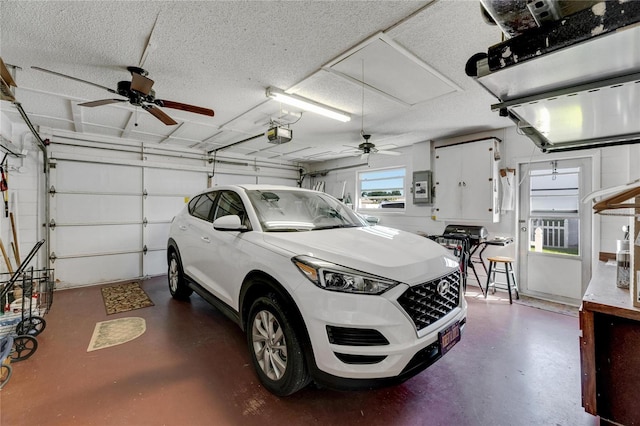 garage with a garage door opener, electric panel, and ceiling fan