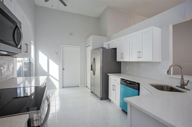 kitchen with tasteful backsplash, white cabinetry, high vaulted ceiling, sink, and stainless steel appliances