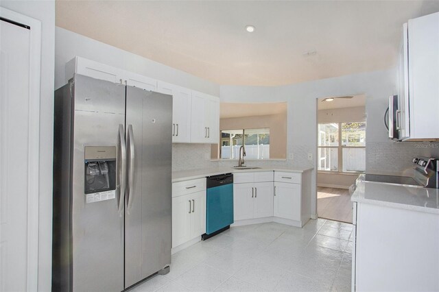 kitchen featuring decorative backsplash, white cabinetry, stainless steel appliances, and sink