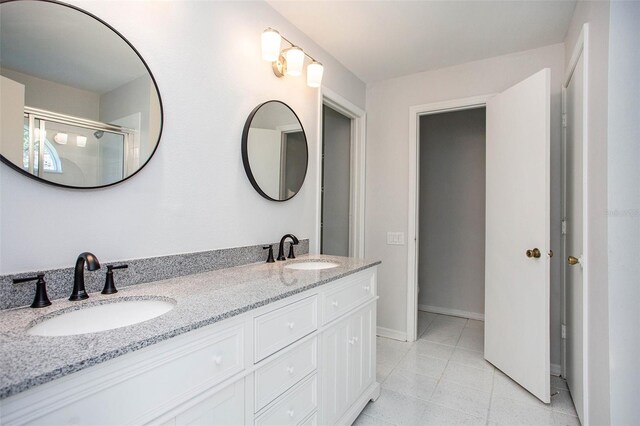 bathroom with vanity, tile patterned floors, and a shower with door