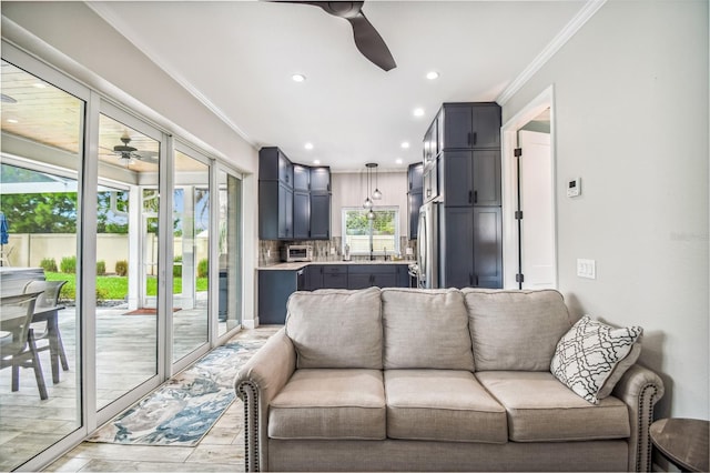 living room featuring a wealth of natural light, ornamental molding, light hardwood / wood-style floors, and ceiling fan