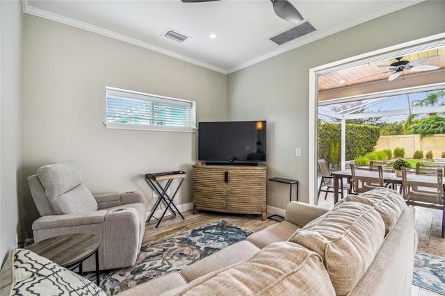 living room featuring crown molding, light hardwood / wood-style flooring, ceiling fan, and plenty of natural light