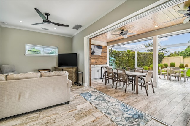 living room featuring light hardwood / wood-style floors, crown molding, wood ceiling, and plenty of natural light