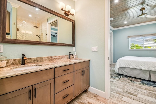 bathroom featuring wood-type flooring, crown molding, vanity, a tile shower, and ceiling fan