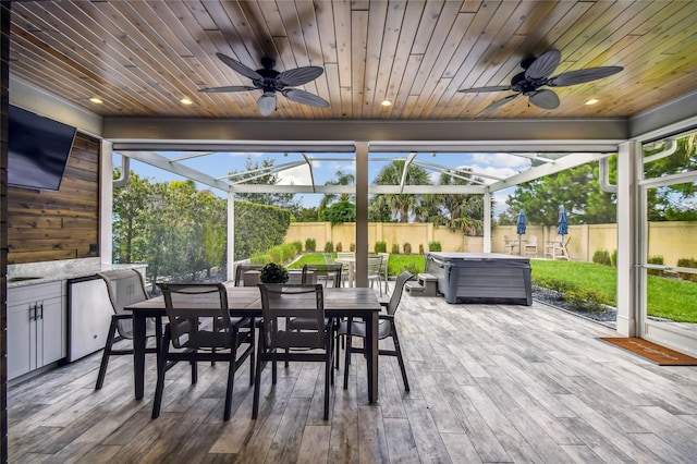 sunroom featuring wood ceiling and ceiling fan