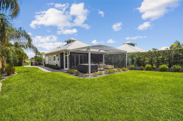 back of property with a patio area, a yard, and glass enclosure