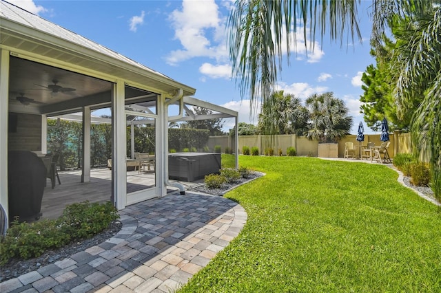 view of yard with a patio, a sunroom, and ceiling fan