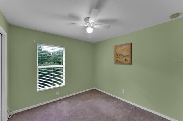 carpeted spare room featuring ceiling fan