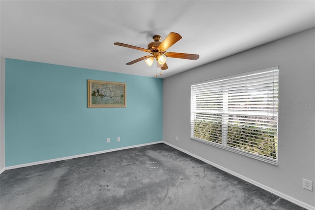 spare room with dark carpet and ceiling fan