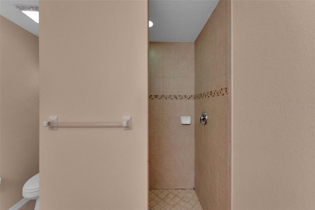 bathroom with toilet and tiled shower