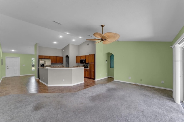 kitchen with stainless steel appliances, vaulted ceiling, a center island, carpet flooring, and ceiling fan