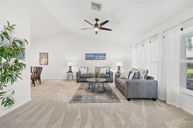 carpeted living room featuring lofted ceiling, a textured ceiling, and ceiling fan