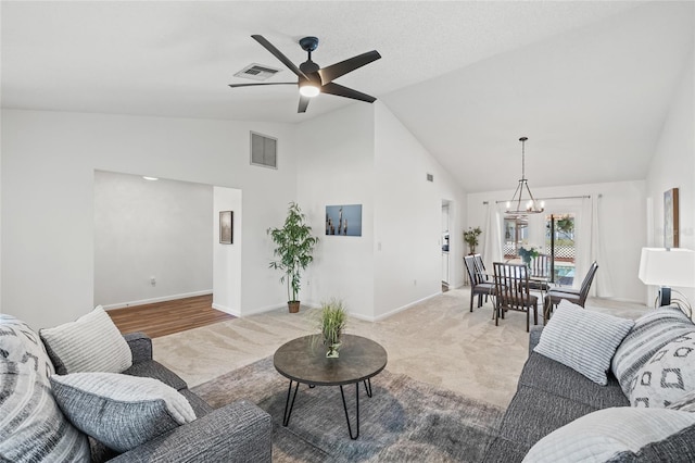 living room with ceiling fan with notable chandelier, light carpet, and lofted ceiling