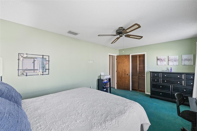 carpeted bedroom featuring a textured ceiling and ceiling fan