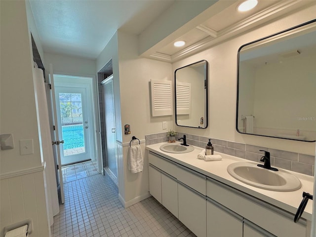 bathroom featuring tile patterned flooring, vanity, decorative backsplash, and a shower with shower door