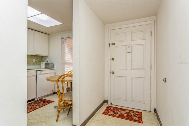 doorway featuring a textured ceiling and a skylight