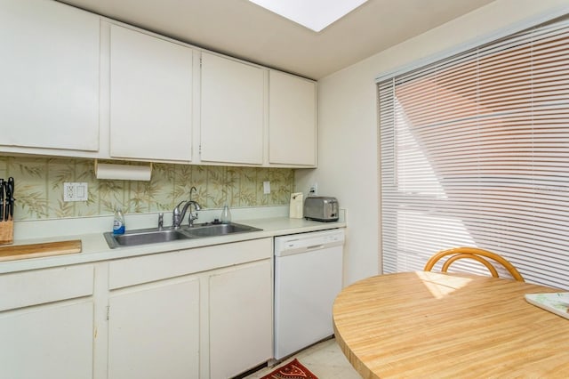 kitchen with white cabinets, sink, and white dishwasher