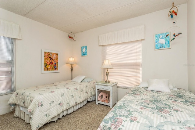 bedroom featuring a textured ceiling and light colored carpet