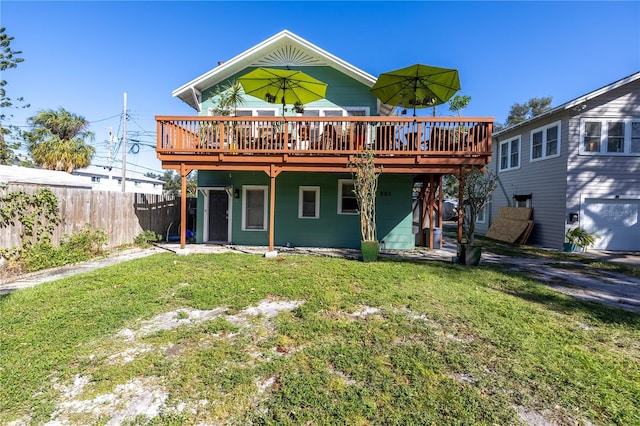 rear view of house featuring a yard and a wooden deck