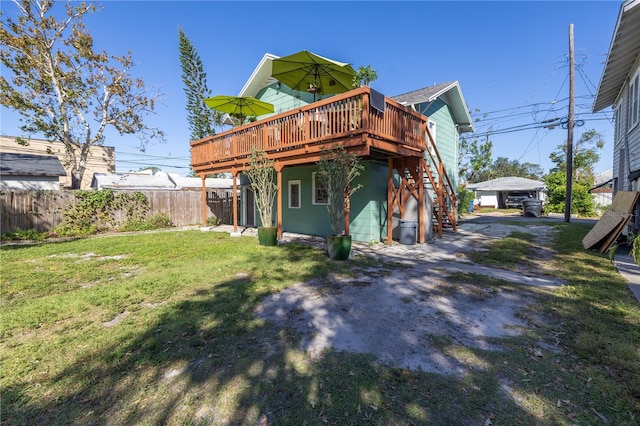 rear view of property featuring a wooden deck and a yard