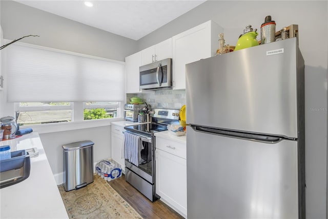 kitchen featuring white cabinetry, tasteful backsplash, appliances with stainless steel finishes, and dark wood-type flooring