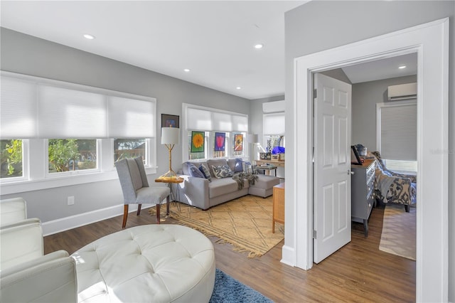 living room featuring a wall mounted air conditioner and hardwood / wood-style flooring