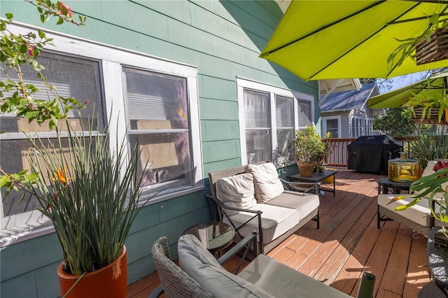 wooden deck with an outdoor hangout area and grilling area