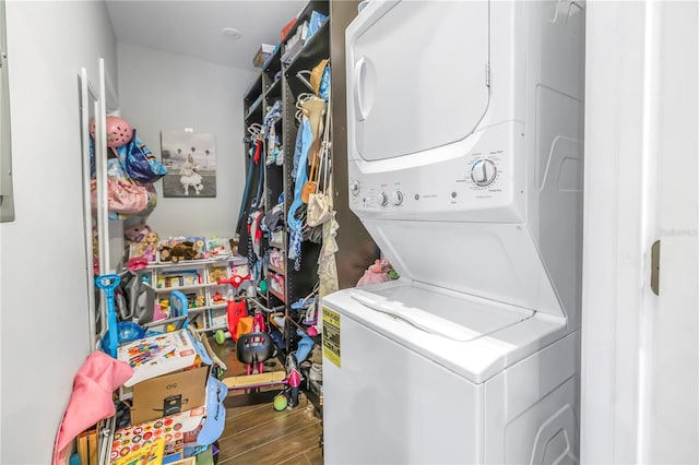 laundry room with wood-type flooring and stacked washer and dryer