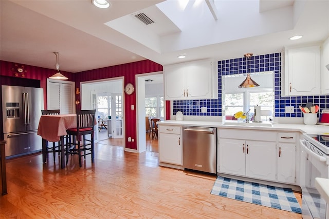 kitchen featuring sink, decorative backsplash, white cabinets, and stainless steel appliances